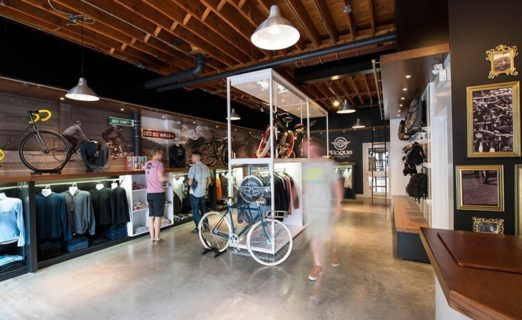 Modern sports retail store interior with wooden fixtures and bright apparel displays.
